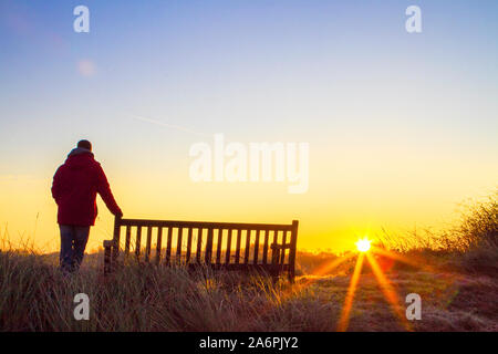 Southport, Merseyside, 28 octobre 2019. Dans un ciel ensoleillé mais froid l'aube, un homme est seul à regarder le lever du soleil sur la réserve naturelle de Marshside RSPB près de Southport Merseyside. Credit : Cernan Elias/Alamy Live News Banque D'Images