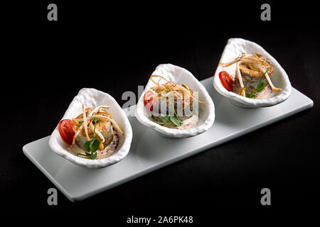 Rouleaux de filet de bar cuit au four farcies aux légumes et sauce aux champignons, sur un fond sombre, l'espace de copie. Banque D'Images