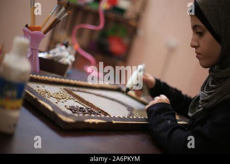 (191028) -- Gaza, 28 octobre, 2019 (Xinhua) -- l'artiste palestinien Abou Hala Qaoud pièces fait de l'art en utilisant les grains de café à son domicile dans le sud de la bande de Gaza ville de Rafah, 28 octobre, 2019. Abu Qaoud, 20 études, les beaux-arts à une université locale à Gaza. Elle vend ses morceaux d'art sur les plates-formes de médias sociaux. (Photo de Khaled Omar/Xinhua) Banque D'Images