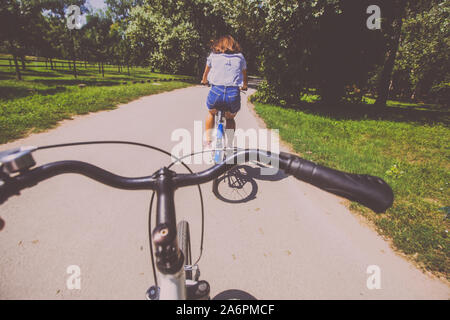 Vue arrière de l'attractive young woman wearing jeans shorts circonscription location dans le parc le jour d'été. Banque D'Images