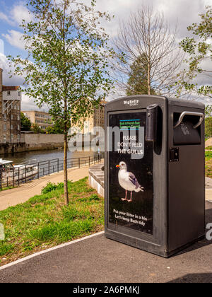 Bin à la Bath Quays Waterside salon à côté de la rivière Avon, Bath, Somerset, Royaume-Uni, avec la baisse de ne pas nourrir les mouettes Banque D'Images