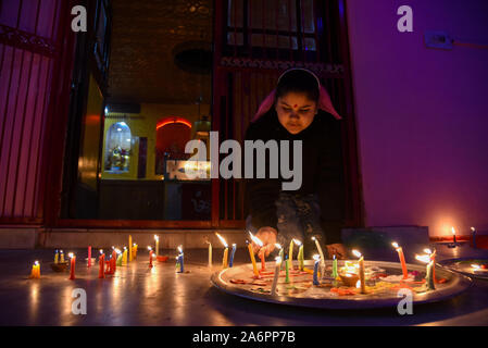 Srinagar, Inde. 27 Oct, 2019. Une jeune fille hindoue cachemirienne bougies allume à l'intérieur d'un temple pendant le festival.Diwali est la réunion de cinq jours de la fête des Lumières, célébrée par des millions d'hindous, sikhs et Jaïns à travers le monde. Diwali qui pour certains coïncide également avec la récolte et fêtes de fin d'année, est un festival de nouveaux commencements et le triomphe du bien sur le mal, et la lumière sur les ténèbres. Credit : SOPA/Alamy Images Limited Live News Banque D'Images