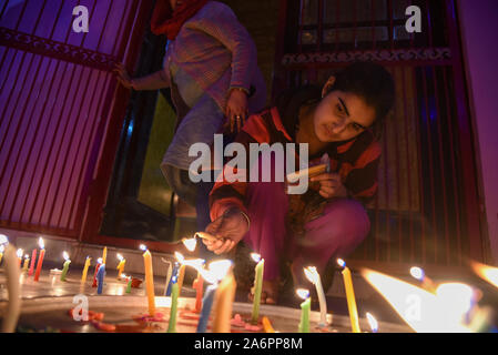 Srinagar, Inde. 27 Oct, 2019. Une jeune fille hindoue cachemirienne bougies allume à l'intérieur d'un temple pendant le festival.Diwali est la réunion de cinq jours de la fête des Lumières, célébrée par des millions d'hindous, sikhs et Jaïns à travers le monde. Diwali qui pour certains coïncide également avec la récolte et fêtes de fin d'année, est un festival de nouveaux commencements et le triomphe du bien sur le mal, et la lumière sur les ténèbres. Credit : SOPA/Alamy Images Limited Live News Banque D'Images