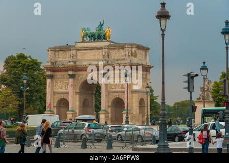 Les personnes qui traversent la route au cours de trafic lourd et la marche de l'Arc de triomphe du Carrousel, un arc de triomphe à Paris situé dans la place du... Banque D'Images