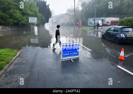 Une personne passe devant un signe de fermeture de route de police dans la commune où la pluie de la Welsh Hills et les hautes marées ont envahi le village, qui se trouve à côté des rives de la rivière Wye, les rendant impraticables. Banque D'Images