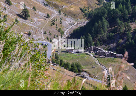 Portrait d'une vallée de montagne avec des rues sinueuses et un petit village alpin avec chalets en pierre dans un beau jour d'été, Chianale, Piémont, Italie Banque D'Images