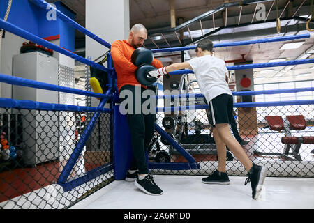 Strong boy ambitieux est d'être enthousiaste à propos de la boxe, pleine longueur voir photo Banque D'Images