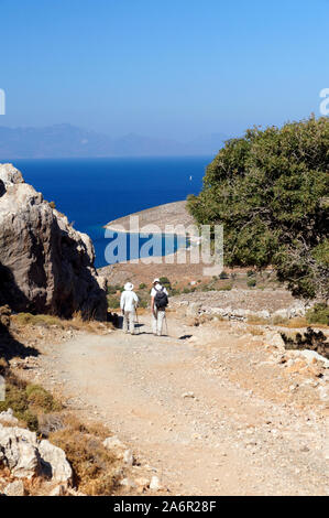 Couple marchant le long du sentier en direction de Livadia Bay de Vounos, Tilos, îles Dodécanèse, sud de la mer Égée, Grèce. Banque D'Images