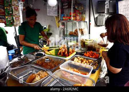 ANTIPOLO CITY, PHILIPPINES - 11 octobre 2019 : Street Food Vendor dans son food vendre un assortiment de snack food au client. Banque D'Images