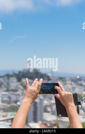 Tourist en utilisant smart phone taking photo de Coit Tower à San Francisco Banque D'Images