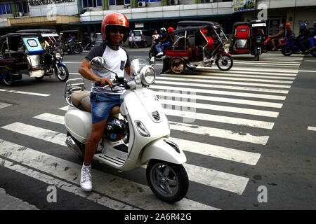 ANTIPOLO CITY, PHILIPPINES - 11 octobre 2019 : pilote moto s'arrêter et de poser pour l'appareil photo pour montrer son scooter rétro. Banque D'Images