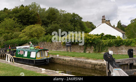 Bateau de Moteur grand classique (étroite) de la voile sur le canal de Leeds Liverpool rural pittoresque, en passant par le verrouillage (1 homme par des portes) - Aramits, North Yorkshire, England, UK Banque D'Images