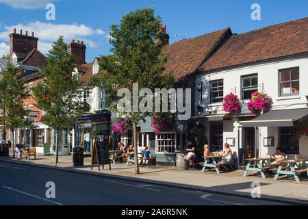 Les gens assis à l'extérieur d'un pub du soleil sur la grande rue, à Marlow, dans le Buckinghamshire avec fleurs colorées Banque D'Images