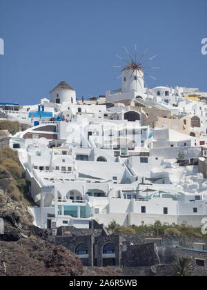 Une vue de dessous de la recherche des moulins à vent à Oia sur falaise volcanique de Santorin ski bleu clair Banque D'Images