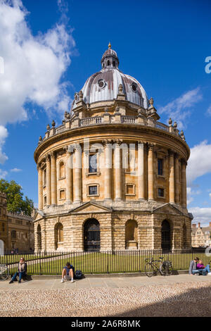 Les élèves s'asseoir au soleil par le garde-corps de la Radcliffe Camera, partie de l'Université d'Oxford Banque D'Images