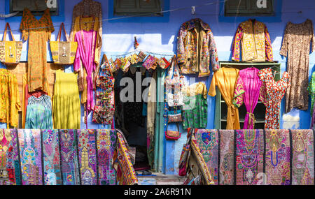 Vue imprenable de vêtements colorés, vestes, sacs et patchwork étendus dehors un petit magasin dans les rues de la ville bleue de Jodhpur. Banque D'Images