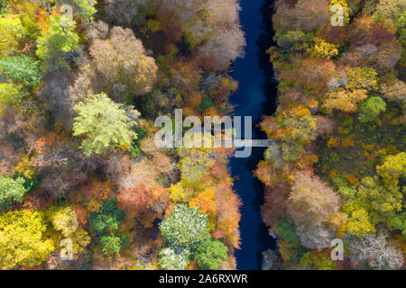 Killiecrankie, Perthshire, Écosse, Royaume-Uni. 28 octobre 2019. Couleurs automnales dans les arbres à côté de la rivière Garry vu à partir d'un drone à Killiecrankie dans le Perthshire. Sur la photo ; passerelle piétonne franchissant la rivière Garry. Iain Masterton/Alamy Live News. Banque D'Images