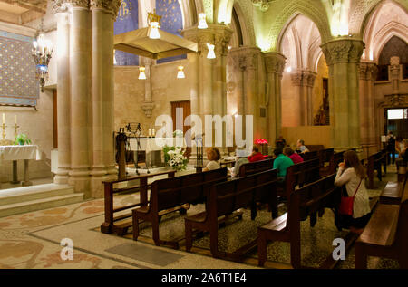 Les gens priant pendant la messe dans la crypte de la Sagrada Familia à Barcelone, Espagne Banque D'Images