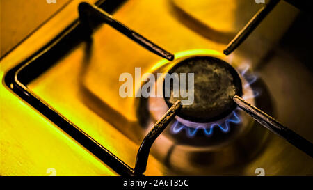 Cuisinière à gaz de combustion avec des tons chauds de jaune de la lumière dans la pièce sombre, libre. Banque D'Images