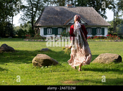 Femme aller dans une maison de pays, Pologne Banque D'Images