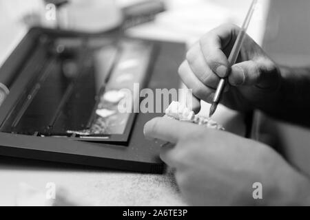 Les mains d'un spécialiste dans le processus de fabrication d'une prothèse dans un laboratoire dentaire Banque D'Images