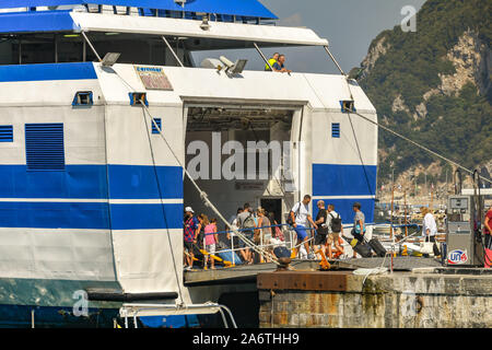 Île de Capri, ITALIE - AOÛT 2019 : Les gens d'embarquer dans un ferry sur la rampe du véhicule dans le port sur l'île de Capri. Banque D'Images