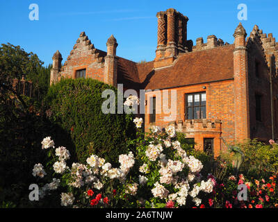 Chenies Manoir et jardin à la fin de l'été dans une belle soirée. Crème pastel roses, dahlias rose, bleu ciel et les grands arbres encadrent la scène. Banque D'Images