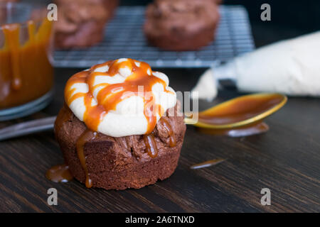 Chai bébé Gâteau Brownie Caramel Fudgey : petits gâteaux brownie surmontée de chai vanille sauce caramel salé et glaçage Banque D'Images