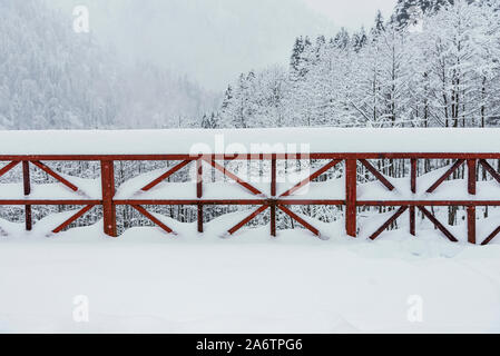 Garde-corps de couleur rouge sur un pont sous blizzard. Banque D'Images