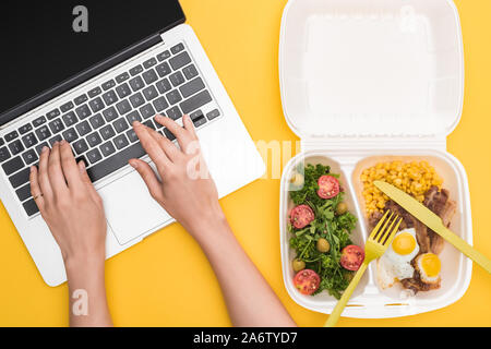 Portrait of woman using laptop et eco emballage avec le maïs, la viande, œufs frits et salade jaune isolé sur Banque D'Images