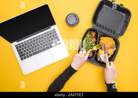 Portrait de femme mangeant de eco emballage avec le maïs, la viande, œufs frits et salade jaune isolé sur Banque D'Images