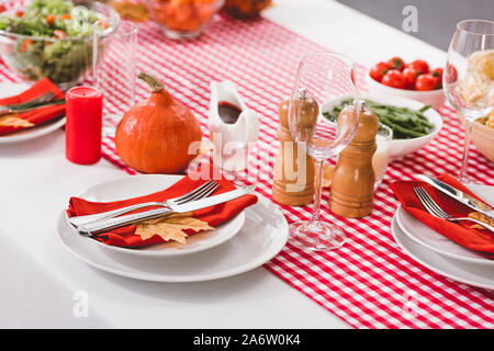 Table avec assiettes, verres, couverts, bougies, moulin à poivre, moulin à sel et de citrouille à jour de Thanksgiving Banque D'Images