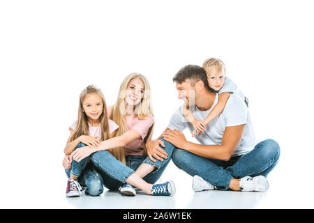 Heureux parents et enfants dans un blue-jean sitting on white Banque D'Images