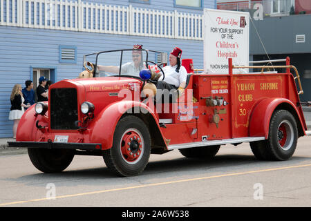 Les membres du Club Shriner conduire un camion de pompier antique pendant la Parade de la fête du Canada tenue le 01 juillet 2019 à Whitehorse, Territoire du Yukon, Canada. Banque D'Images