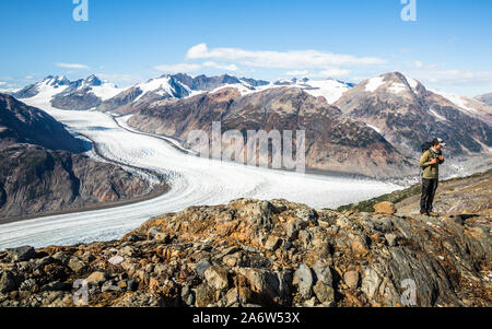 Randonneur sur une crête de montagne au-dessus du glacier du saumon au Canada. Le glacier est situé sur la frontière de l'Alaska. Banque D'Images