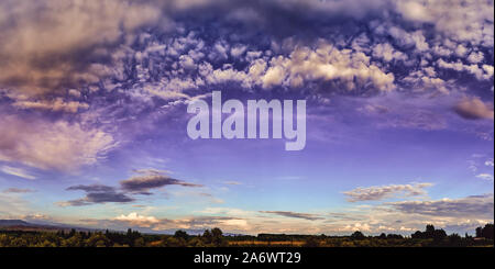 Panorama. Fairytale dawn, coucher de soleil avec des nuages colorés, sur fond de collines Banque D'Images