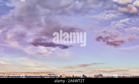 Panorama. Fairytale dawn, coucher de soleil avec des nuages colorés, sur fond de collines Banque D'Images