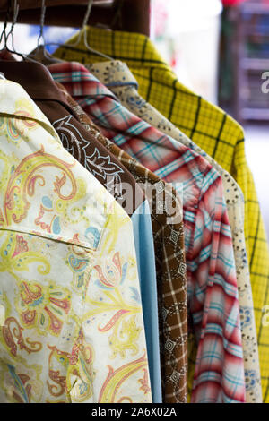 Vintage western style long manches longues avec des motifs et couleurs accroché dans un magasin d'antiquités à Thorp, Washington. Banque D'Images