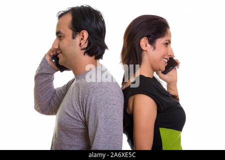 Persan heureux couple smiling while talking on mobile phone toget Banque D'Images