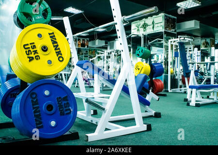 Professional rouge, vert, bleu les haltères et disques de poids sur l'arrière-plan de la salle de remise en forme. Banque D'Images