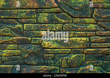 Peint marbré mur de pierre. La peinture fluorescente sur fond de rock. Texture vert et jaune dans un style moderne. Mur de briques différentes. Abstract pattern. Banque D'Images