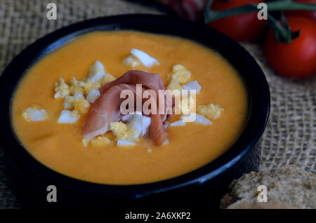 Close up of Salmorejo, soupe de tomate froide crème, servi avec du jambon serrano et oeufs durs. Banque D'Images