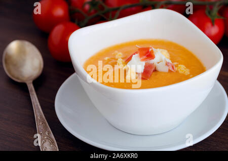 Close up of Salmorejo, soupe de tomate froide crème, servi avec du jambon serrano et oeufs durs. Banque D'Images