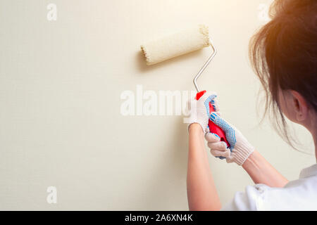 Woman holding paint roller Banque D'Images