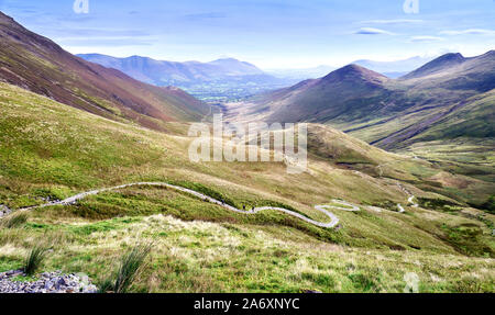 Trois randonneurs lointain à monter un escalier Rocky path de Coledale Beck qui mène à Hopegill la tête, Crag Hill et Grasmoor dans le Lake District. Banque D'Images