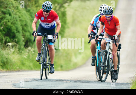 ROTHBURY, Newcastle upon Tyne, England, UK - Juillet 06, 2019 : Trois coureurs travaillant dur sur une colline à l'événement de course cyclone de Newcastle à ép Banque D'Images