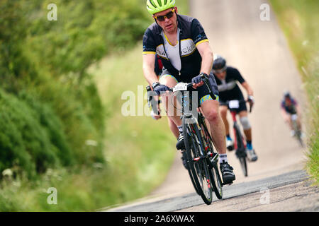 ROTHBURY, Newcastle upon Tyne, England, UK - Juillet 06, 2019 : Un cycliste fatigué à la circonscription d'une colline à l'événement de course cyclone à Newcastle Banque D'Images