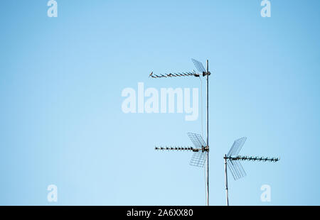 Trois antennes de télévision pour l'analogique et la télévision numérique terrestre sur le mât installé sur un toit en Espagne, avec grill et câbles Banque D'Images