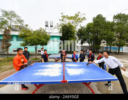 Jiangxi, Chine. 28 Oct, 2019. Huang Xinglai (1e R) joue au tennis de table avec les élèves de l'école primaire de Huping Cunli Township dans Le'un pays de l'est de la Chine, la Province du Jiangxi, le 28 octobre 2019. Huang Xinglai, 61, utilisé pour être un professeur à l'école primaire d'Wanchong Anli Township et a pris sa retraite en juillet 2018. Il est allé à l'école primaire de Huping Cunli Township et a travaillé comme enseignant en milieu rural à nouveau en janvier de 2019 de répondre à l'appel du gouvernement local. Afin de se concentrer sur l'enseignement, Huang vit à l'école avec d'autres jeunes enseignants. Source : Xinhua/Alamy Live News Banque D'Images