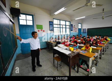 Jiangxi, Chine. 28 Oct, 2019. Huang Xinglai donne une classe pour les élèves de l'école primaire de Huping Cunli Township dans Le'un pays de l'est de la Chine, la Province du Jiangxi, le 28 octobre 2019. Huang Xinglai, 61, utilisé pour être un professeur à l'école primaire d'Wanchong Anli Township et a pris sa retraite en juillet 2018. Il est allé à l'école primaire de Huping Cunli Township et a travaillé comme enseignant en milieu rural à nouveau en janvier de 2019 de répondre à l'appel du gouvernement local. Afin de se concentrer sur l'enseignement, Huang vit à l'école avec d'autres jeunes enseignants. Source : Xinhua/Alamy Live News Banque D'Images